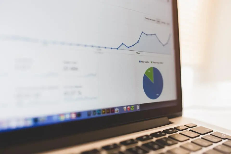 A laptop screen showing a website analytics dashboard with a traffic trend graph